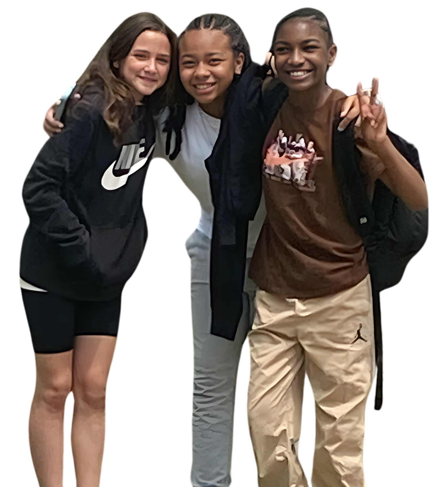 Three young women smiling and hugging each other, dressed in casual athletic clothing and backpacks.