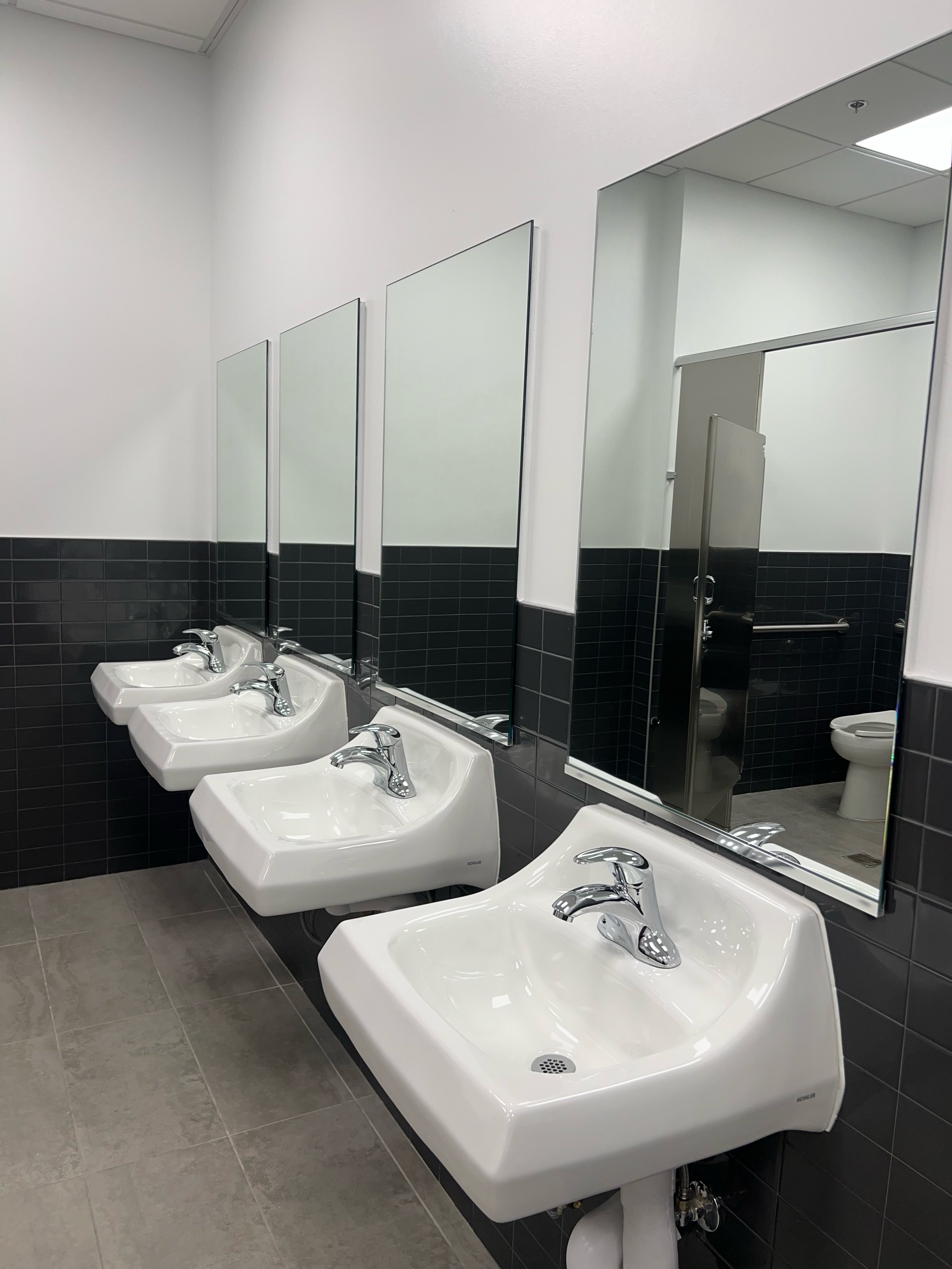 Public restroom sinks cleaned and sanitized during commercial cleaning.