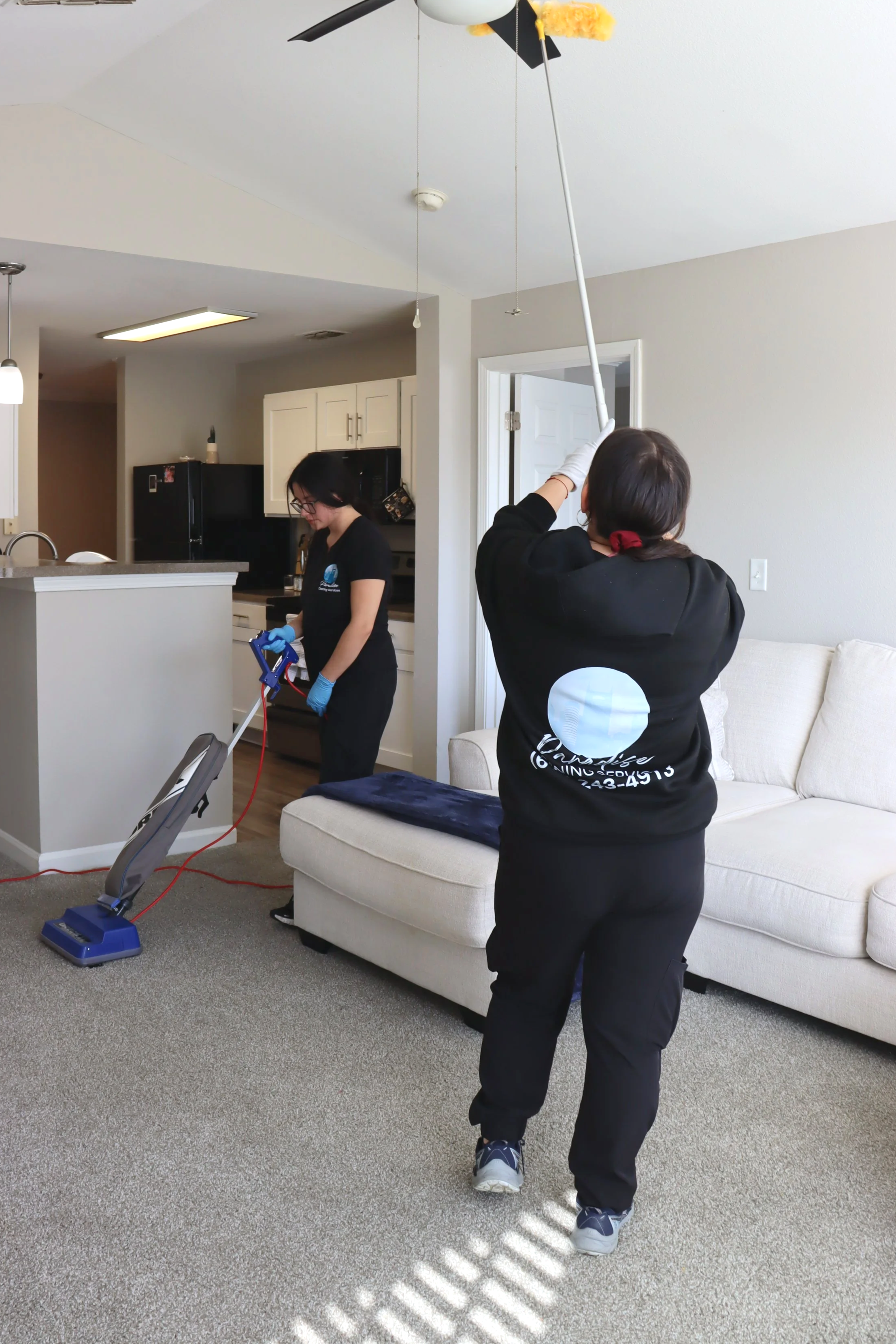 Paradise Cleaning team disinfecting living room surfaces during deep cleaning service.