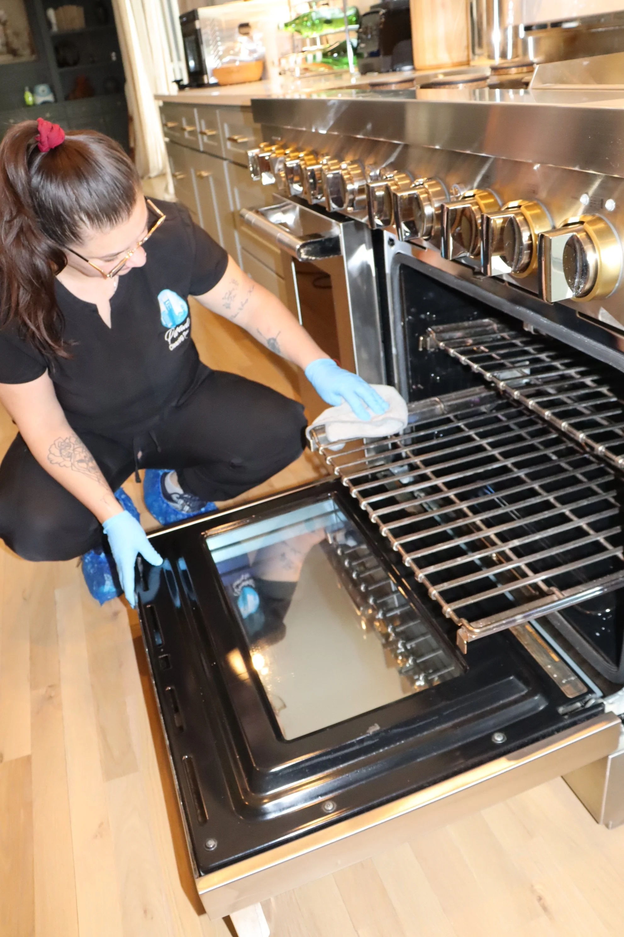 Cleaning technician scrubbing oven interior during deep kitchen cleaning service.