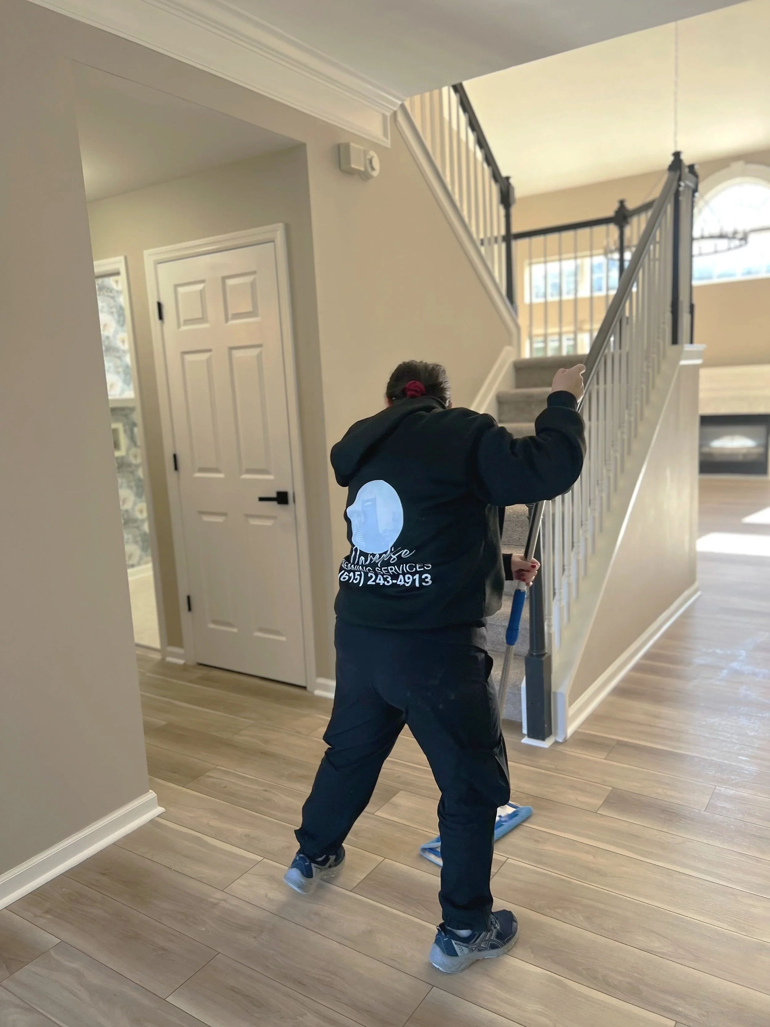 Hardwood hallway floor being mopped during residential cleaning service.