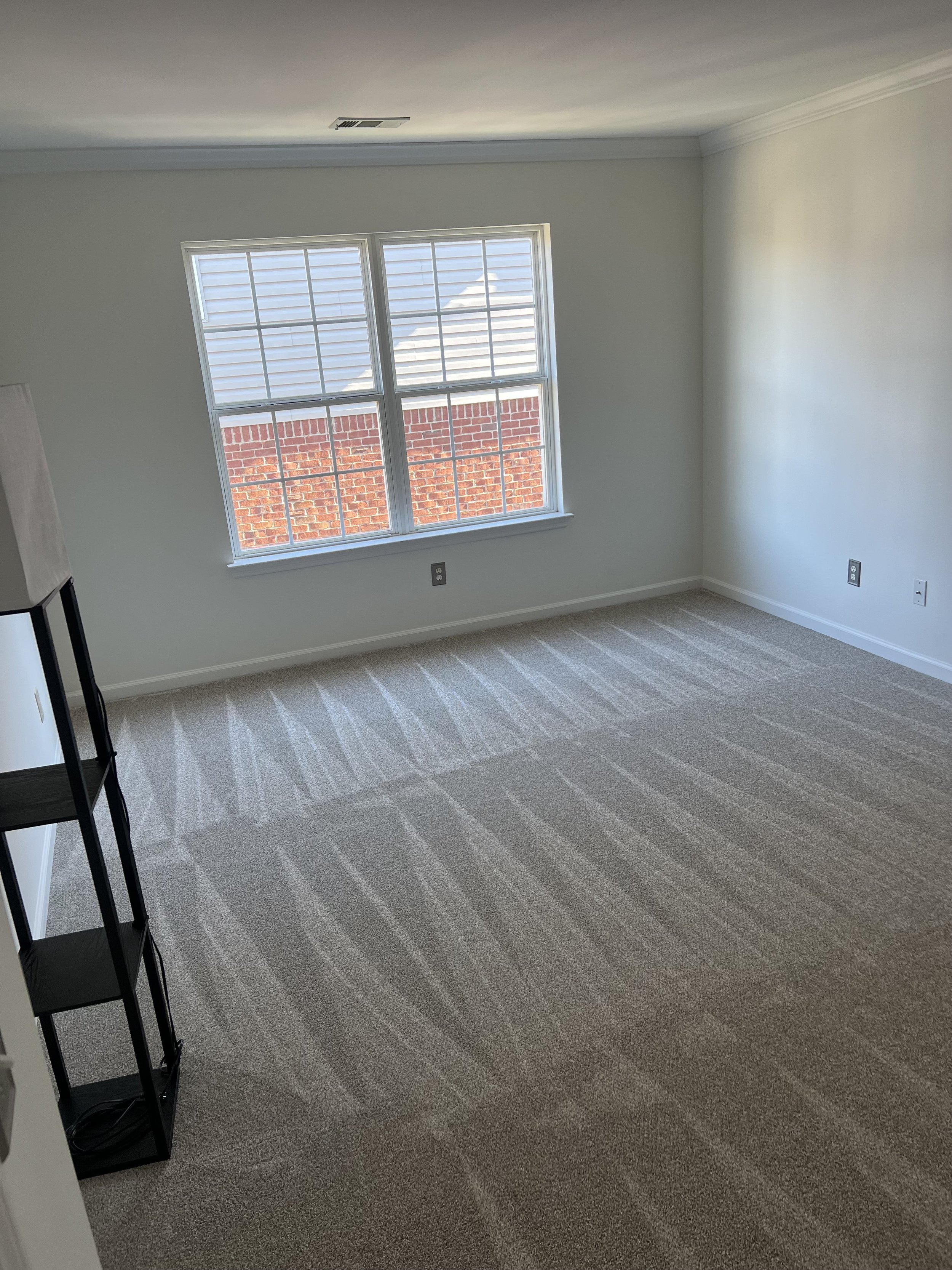 Vacant carpeted room vacuumed and refreshed for new occupant