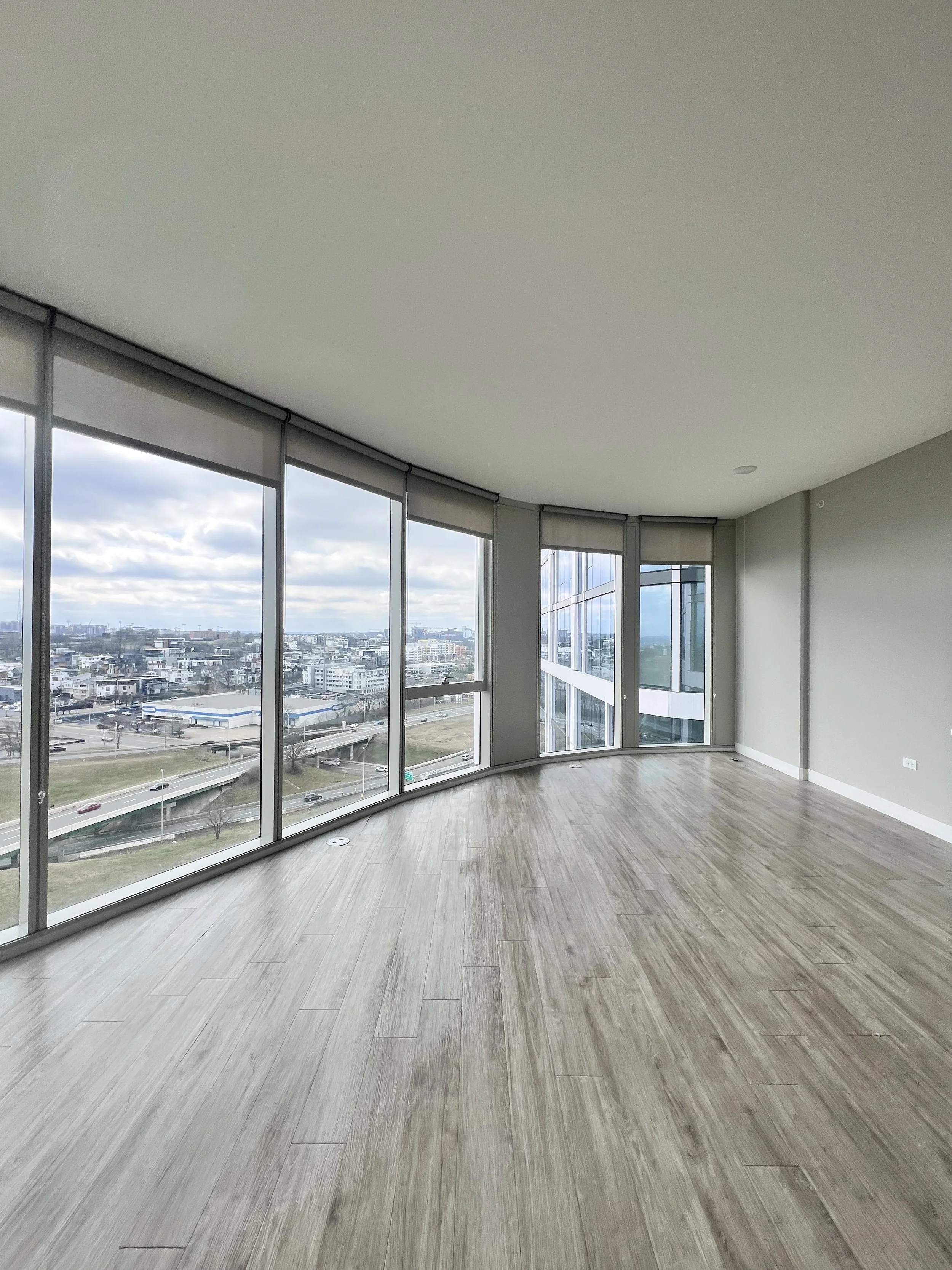 Empty high-rise apartment with floor-to-ceiling windows ready for move-in cleaning.
