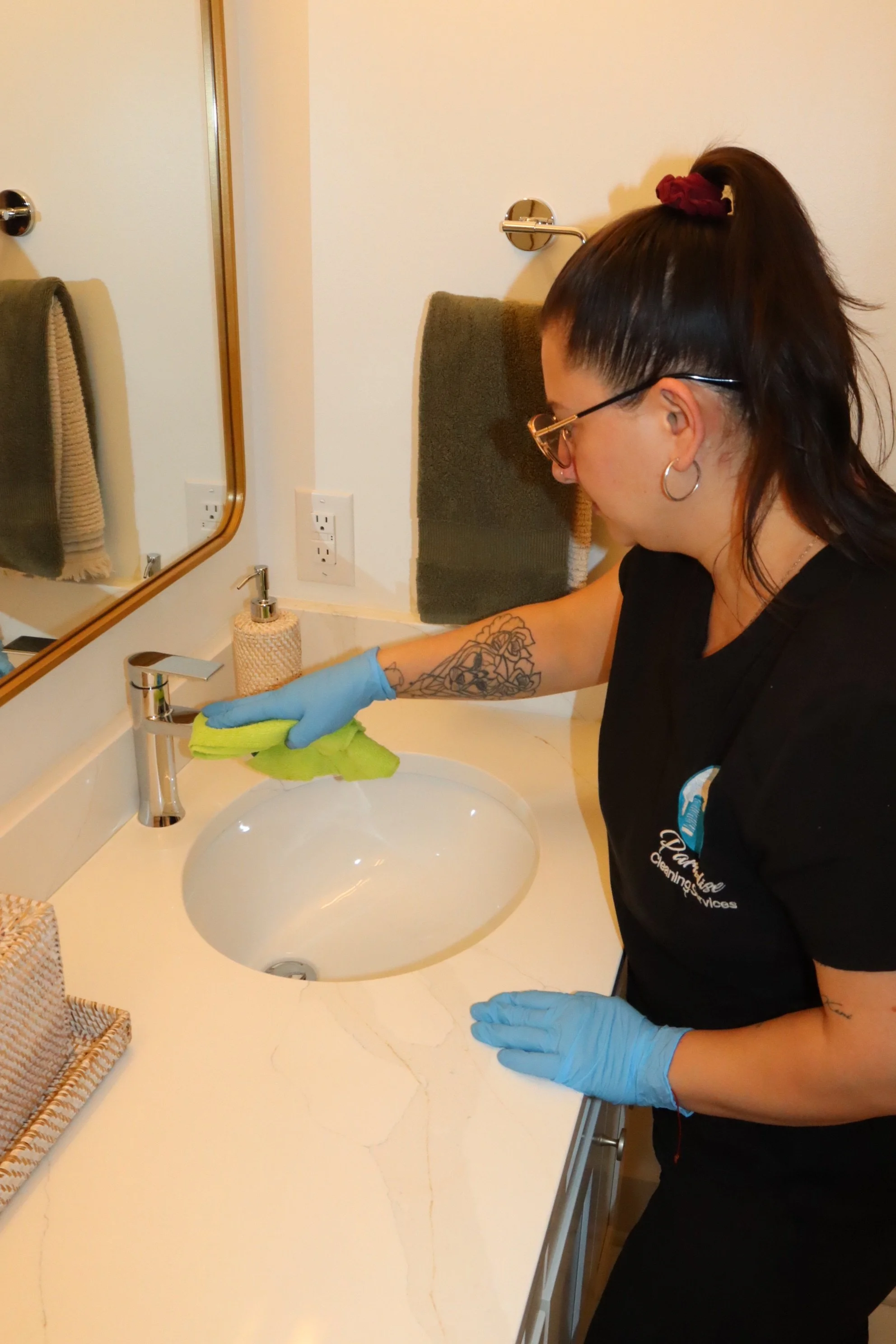Bathroom sink being wiped and sanitized during home cleaning service.
