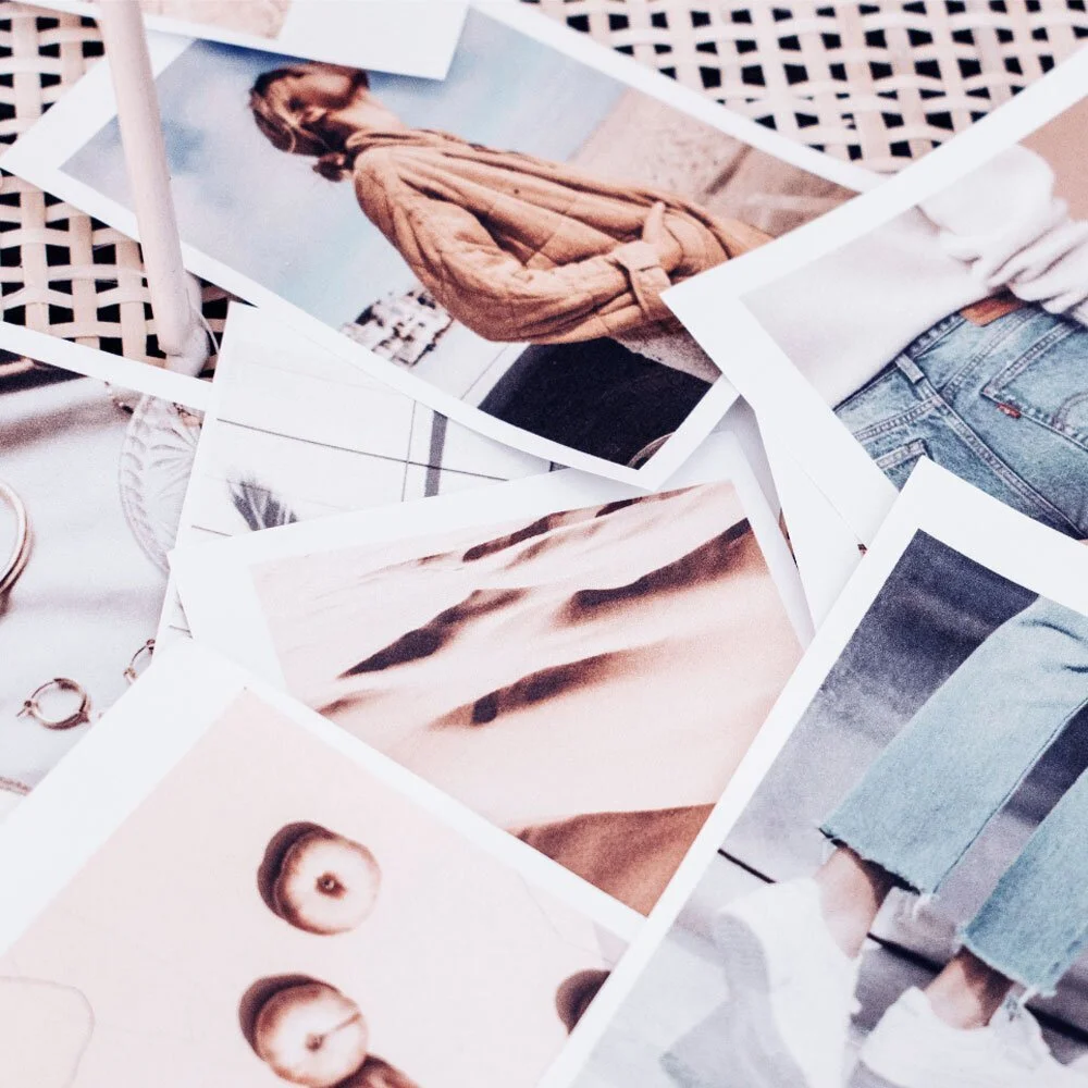 A collection of printed photographs laid out on a surface, featuring people, landscapes, and objects in various settings.