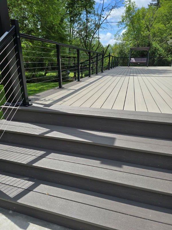 Completed PVC deck installation with cable railings and wide stairs in Maple Valley