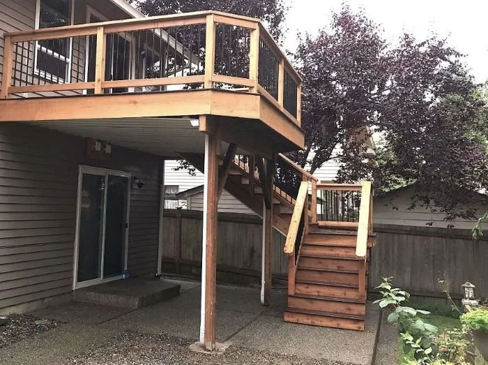 Existing elevated deck prior to under-deck waterproofing, showing open framing and exposed area below