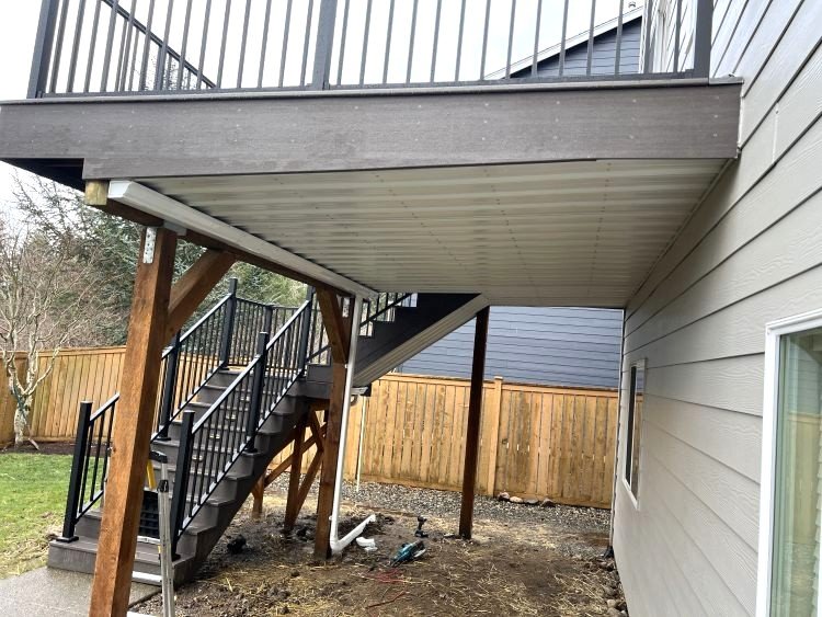 Under-deck waterproofing system installed beneath an elevated deck to create a dry, protected area below