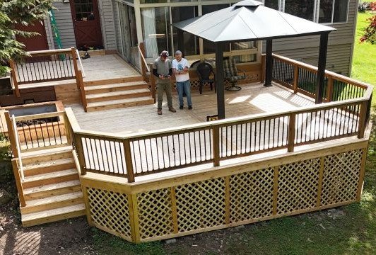 Completed custom deck with homeowners during the final walkthrough by Petra Decks in King County, WA.