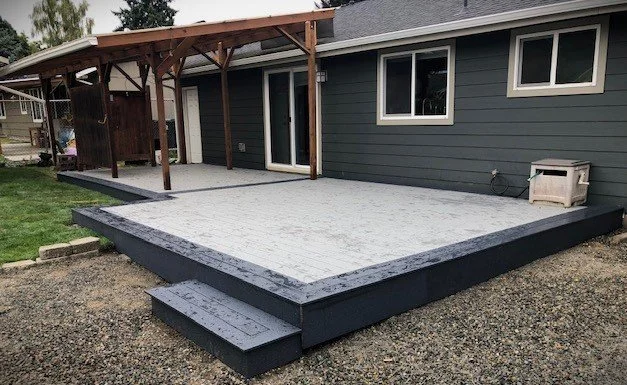Covered deck with waterproofed surface and attached roof structure behind the home