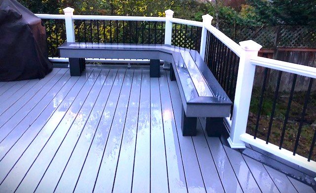 Custom built-in deck benches integrated into a composite deck with aluminum railings, creating comfortable outdoor seating by Petra Decks in King County, WA.