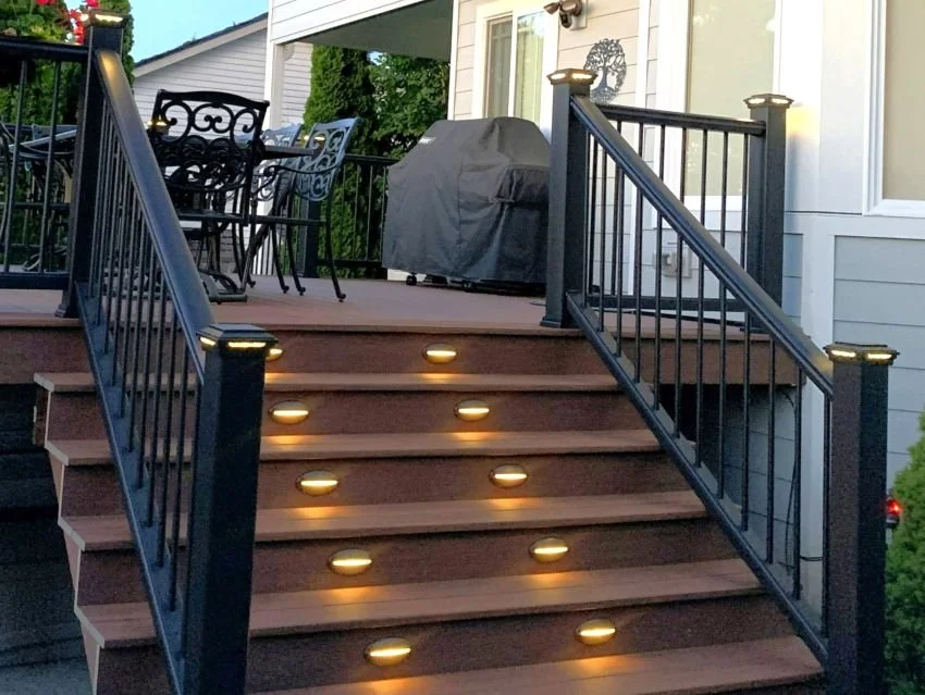Integrated deck step lighting with illuminated stairs and railing posts