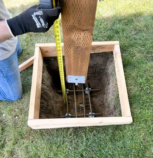 Structural deck repair showing a new deck post footing, reinforced concrete pier, and post base installation completed by Petra Decks in King County, WA.