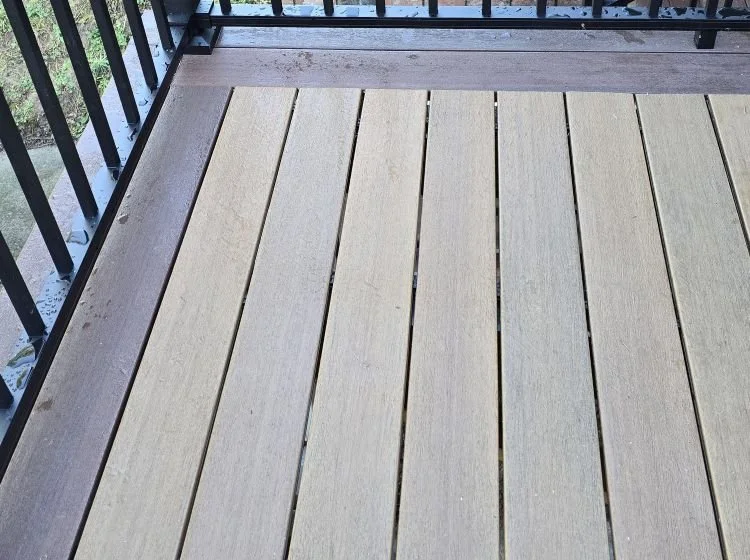 Composite decking with picture-frame border and black aluminum railing installed on a custom deck in Kent, WA