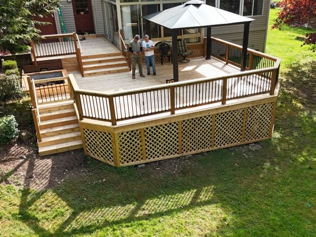 Completed residential deck with homeowner and team during final project walkthrough