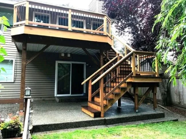 Elevated deck construction in Sammamish WA with structural framing, support posts, and stairs designed for sloped yard and drainage conditions