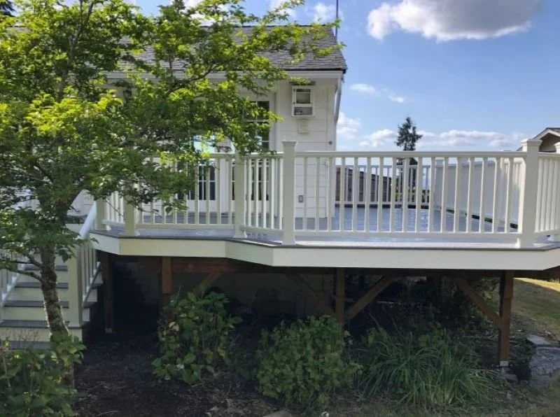 Custom elevated composite deck with white railings built by Petra Decks for a homeowner in King County.