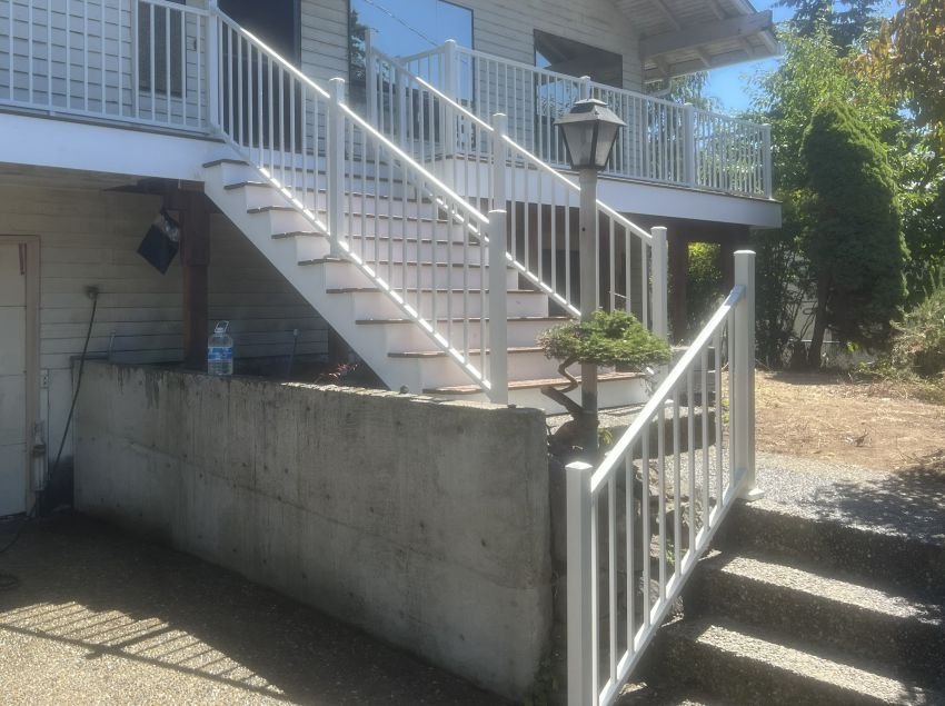 Completed Renton deck replacement with Trex composite decking, white railing, and rebuilt stairs