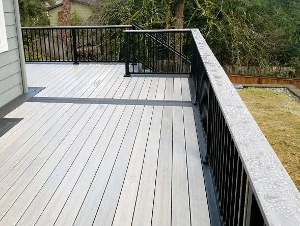Deck contractor in Federal Way WA installing PVC decking with black railing on elevated deck built for durability and moisture resistance