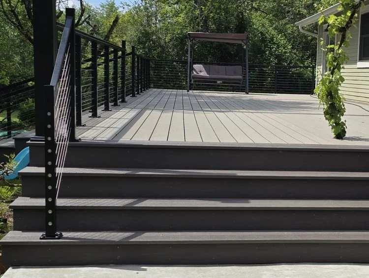 Structural PVC deck replacement in Maple Valley featuring Fiberon Promenade PVC decking, RailFX stainless steel cable railing, and rebuilt stairs by Petra Decks.