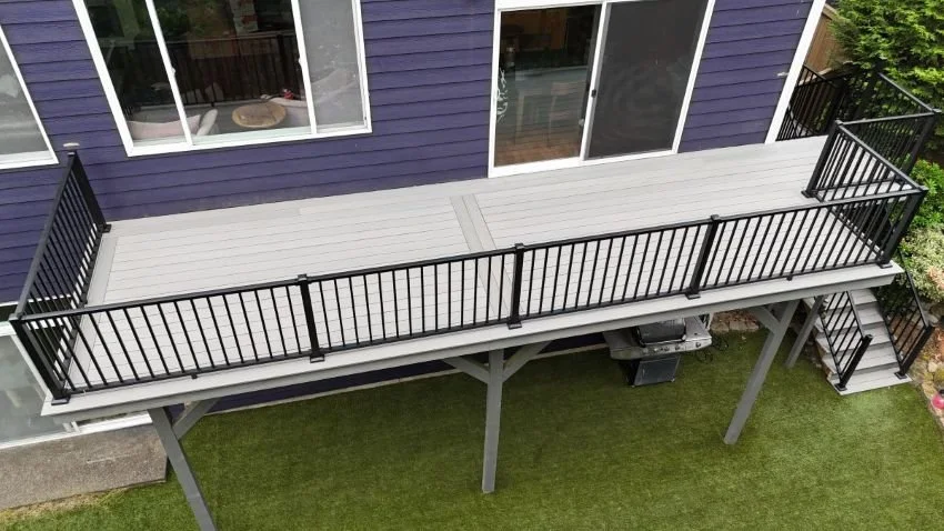 Completed decking and railing replacement project in Snoqualmie, WA featuring TimberTech composite decking, black aluminum railing, reinforced framing, and rebuilt stairs.