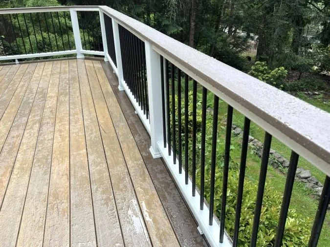 white pvc deck railing with black metal balusters on residential deck
