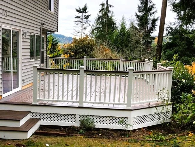 Composite decking replacement and installation with white railings completed by Petra Decks for a King County homeowner.