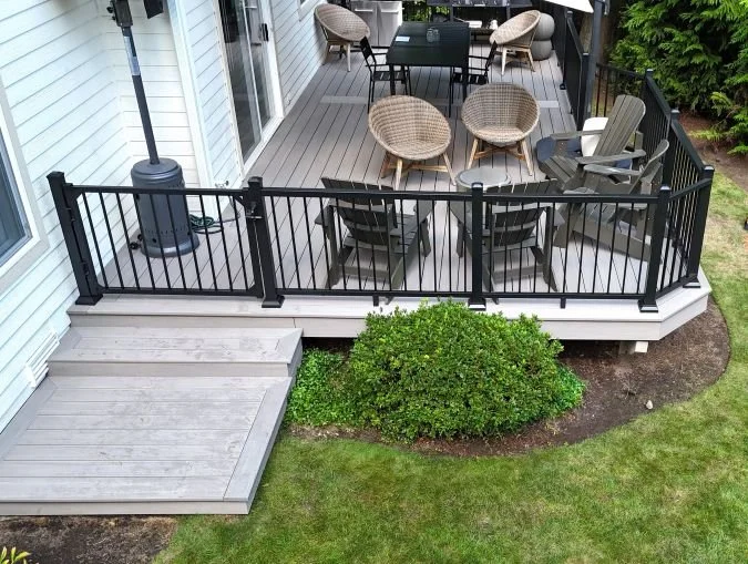 Deck renovation with updated decking surface, stairs, and metal railing