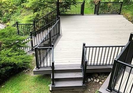 Deck construction in Kent WA with stairs and railing on a sloped backyard