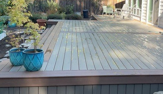 TimberTech composite deck replacement in Sammamish WA with Silver Maple decking, Brown Oak trim, and wide stairs leading to backyard seating area