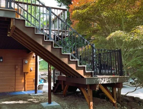 Structural-first elevated deck construction showing engineered framing, support beams, and stair construction by Petra Decks in King County.