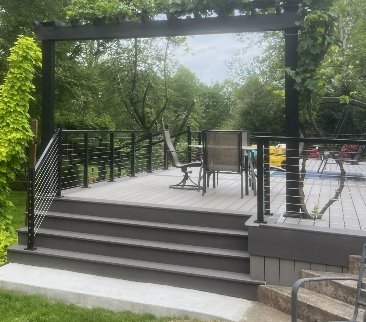 Modern PVC deck replacement project in Sammamish, WA featuring cable railings, wide stairs, and a custom pergola for low-maintenance outdoor living.