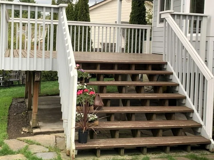 Aging backyard deck in Maple Valley, WA before renovation with worn stairs, outdated railings, and original wood framing.