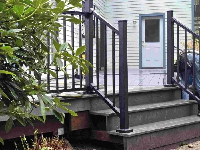 Custom deck construction in Kent, WA with pvc decking, black aluminum railing, and stair transition designed for long-term durability and outdoor usability.