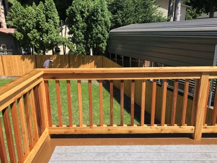 Traditional wood deck railing with vertical balusters and natural finish