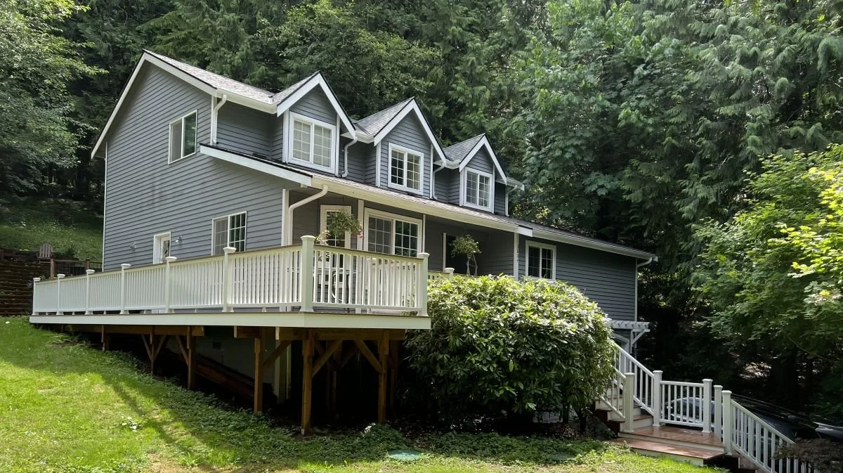 Elevated deck designed for a sloped hillside home in North Bend, WA with engineered structural support and white railings.