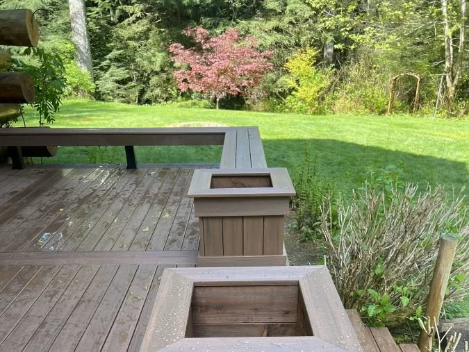 Recent deck construction project in Covington WA showing composite decking, built-in planter boxes, and backyard layout designed for outdoor living