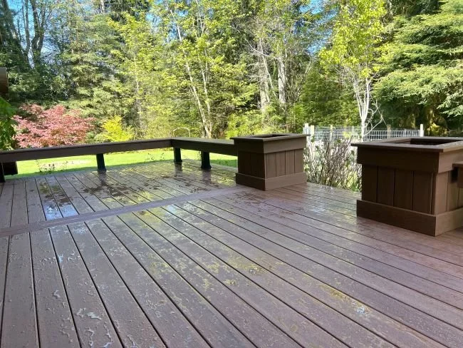 Deck renovation with updated decking surface and built-in planter features