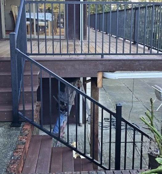 Composite deck replacement with rebuilt stairs and black aluminum railing in Maple Valley, WA
