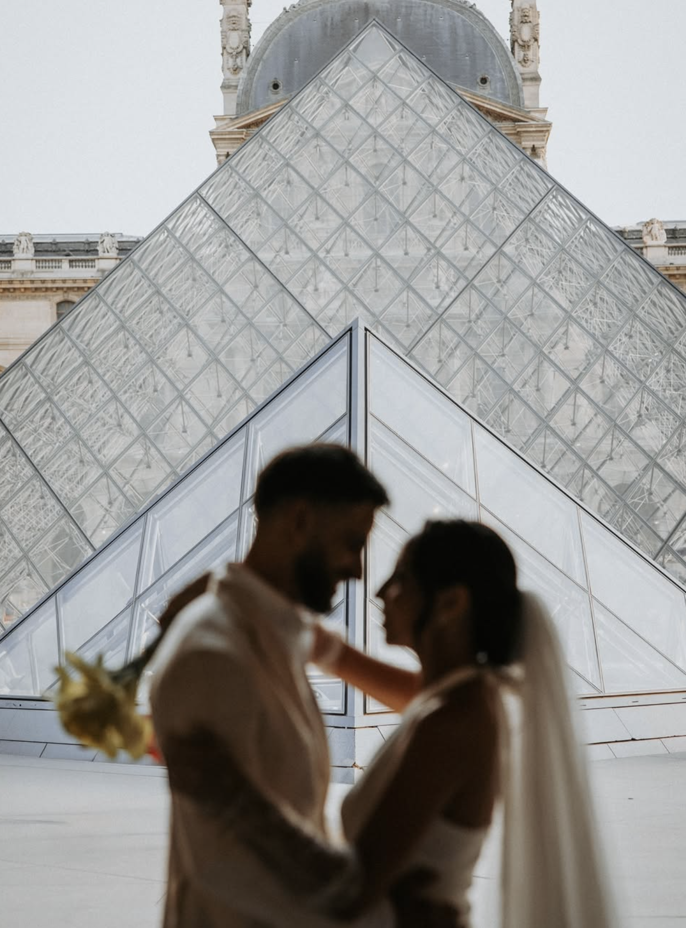 Een stel dat dicht bij elkaar staat, met de Eiffeltoren op de achtergrond, in Parijs.