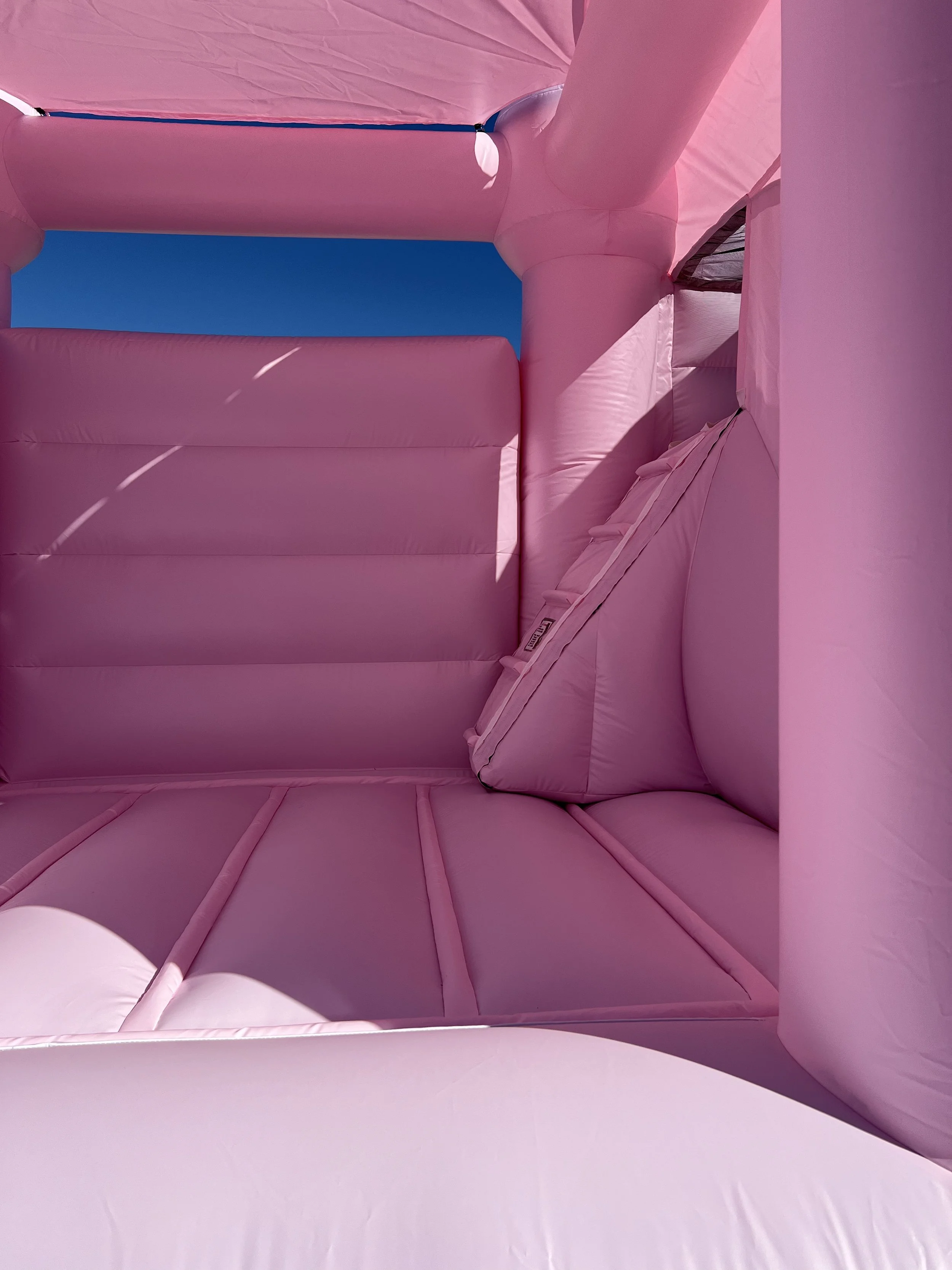 Children playing outdoors with white balloons floating in the air.