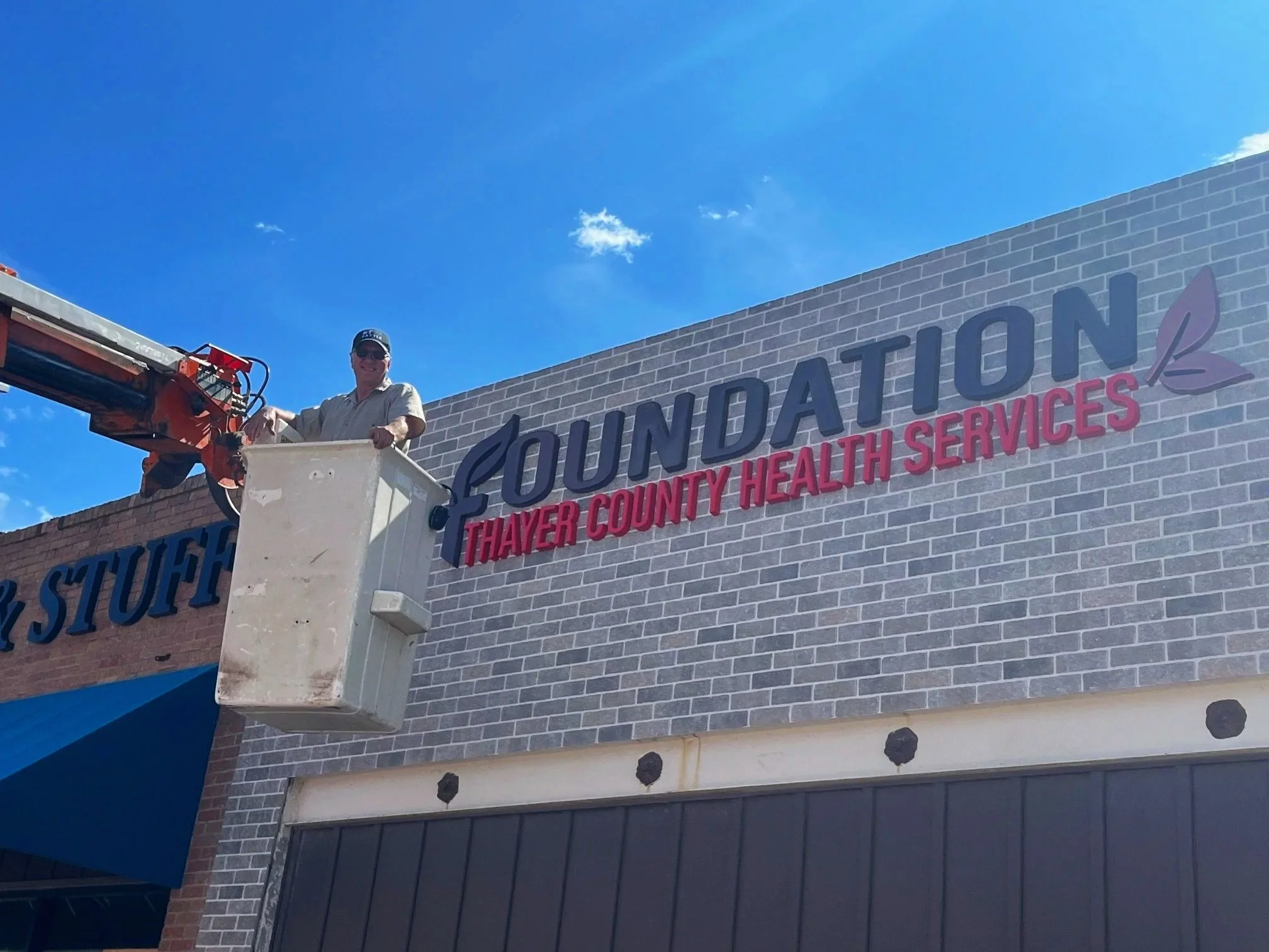 Michael Burger is installing letter Signage for Thayer County Health Services in Hebron, NE