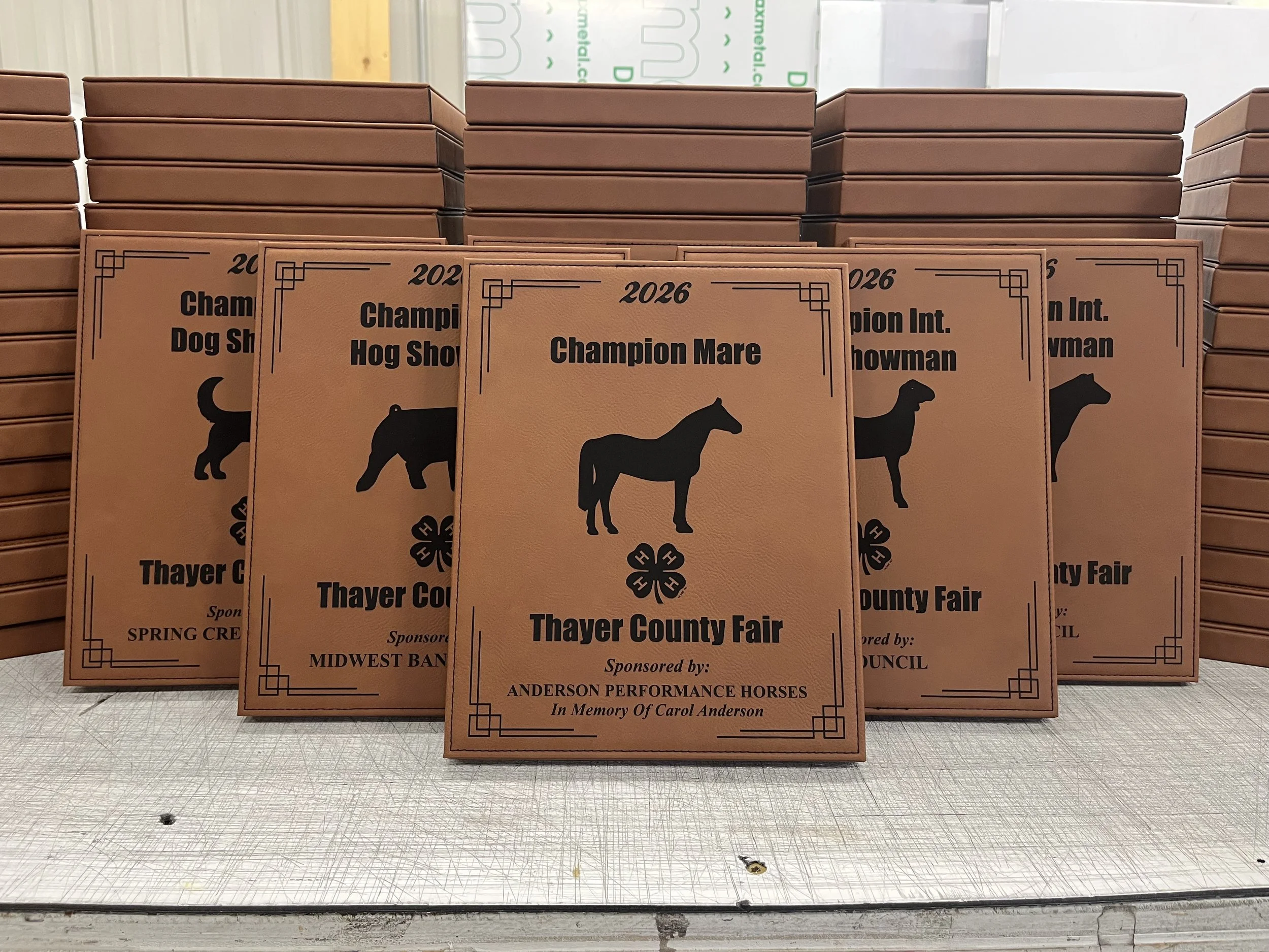 Several lasered leatherette plaques for Thayer central 2026 fair, each plaque has a different animal with a different sponsor