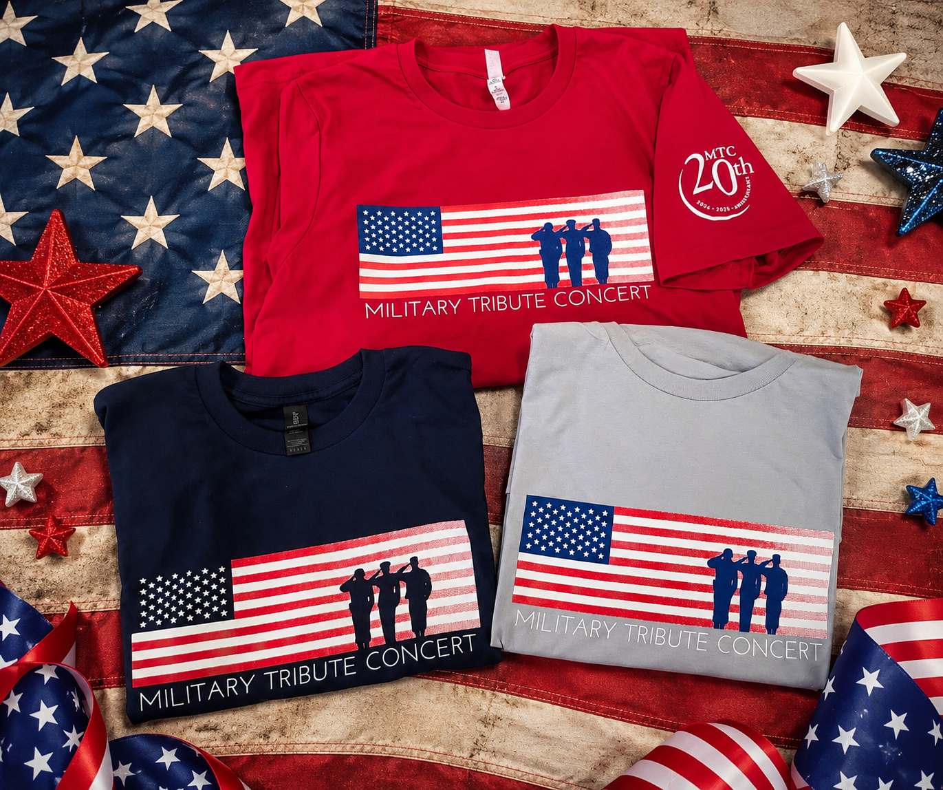 Three Screen-Printed T-shirts with patriotic designs laid out on a distressed American flag background, surrounded by star-shaped decorations and ribbons in red, white, and blue.