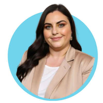 A woman with long dark hair, wearing a beige blazer and white shirt, smiling against a blue background.
