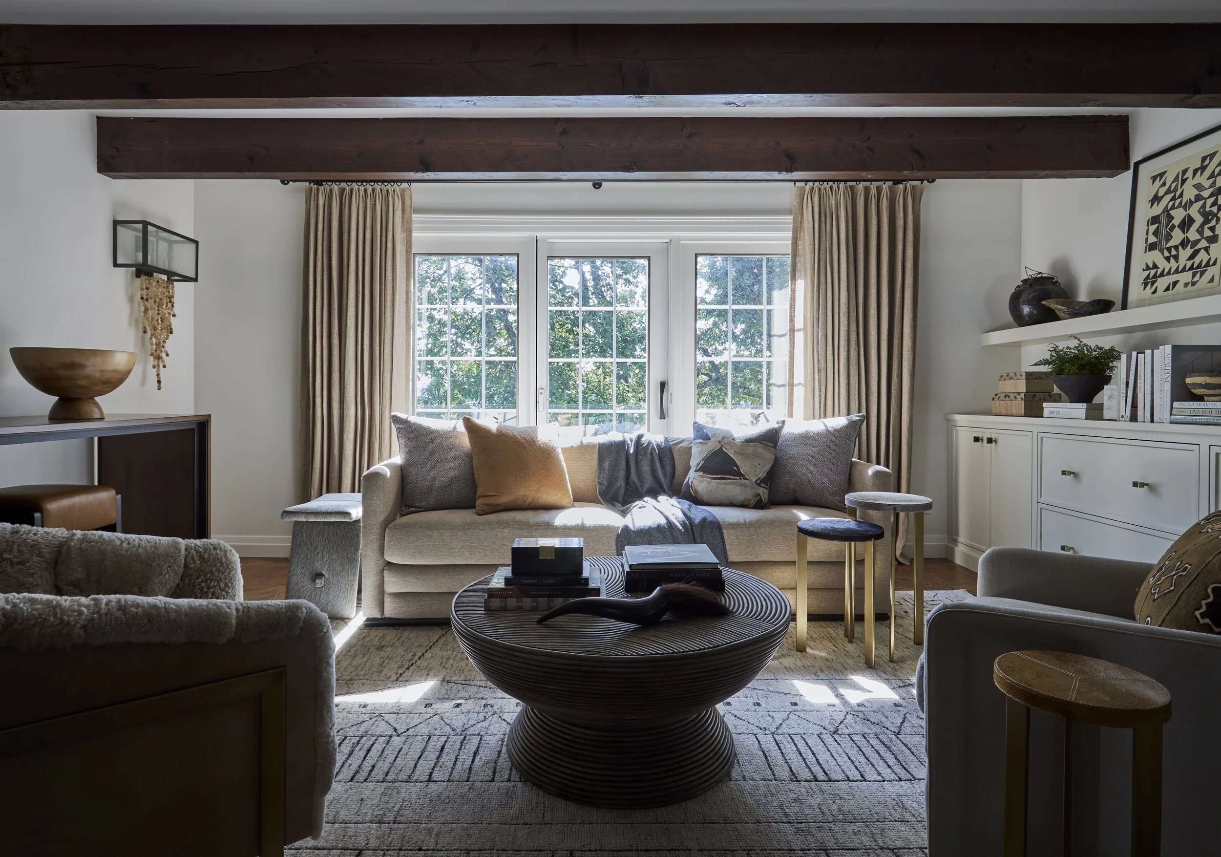 sitting room with white built-in cabinets. Inset panel with slim shaker cabinets. floating shelf. Large reclaimed beams in sitting room.