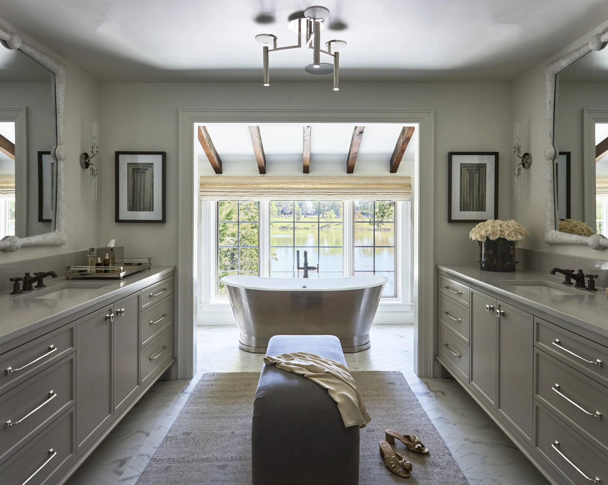 Primary Bathroom with face-off vanities and freestanding bathtub. Reclaimed beams in bathroom. Bathtub in front of windows. Polished Nickel in bathroom.