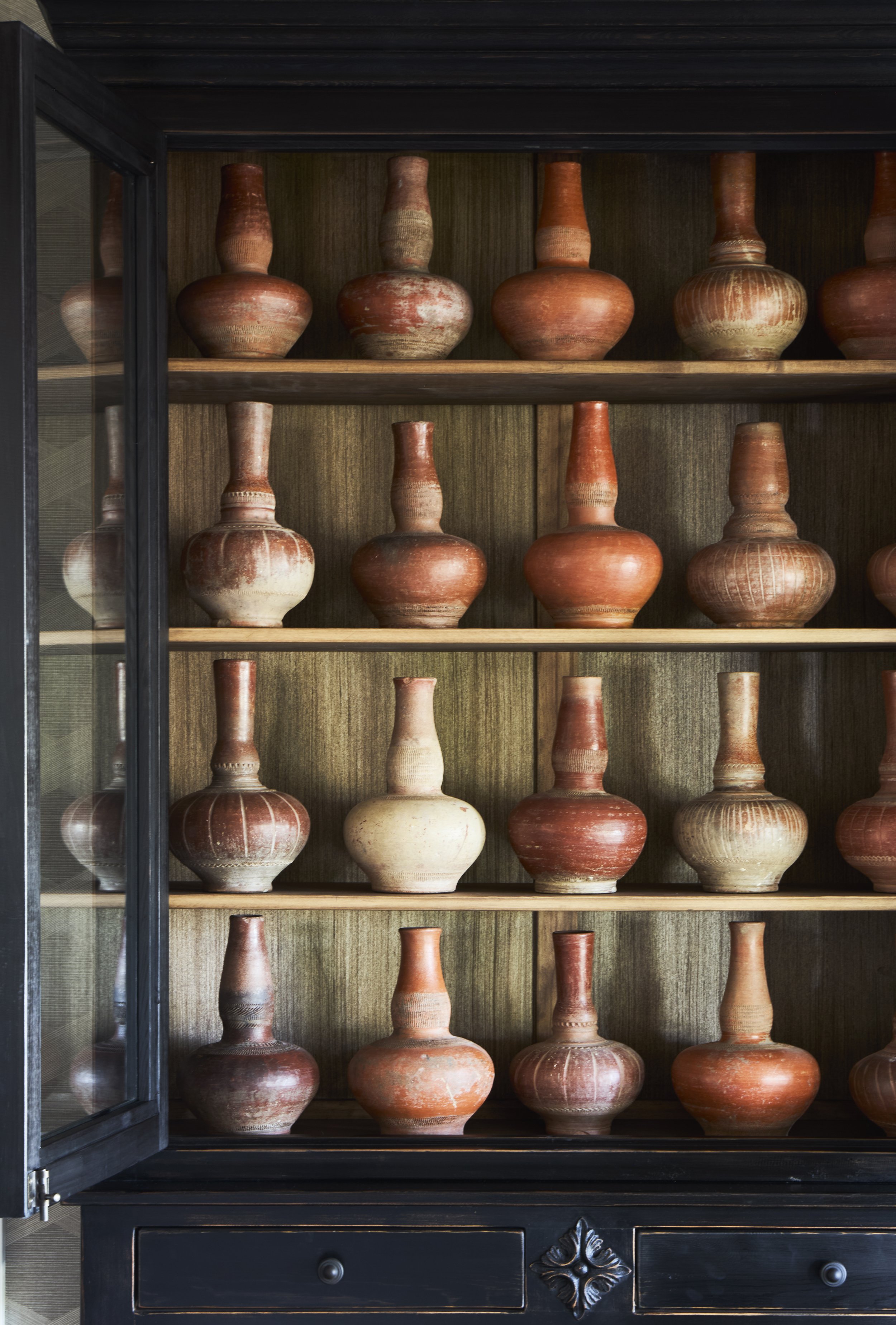 decorative vases fill an antique reclaimed cabinet.