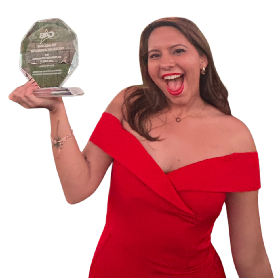 A woman in a red off-shoulder dress holding a glass award and smiling.