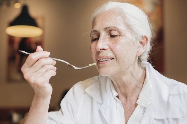 Senior woman safely enjoying meal with family after dysphagia treatment